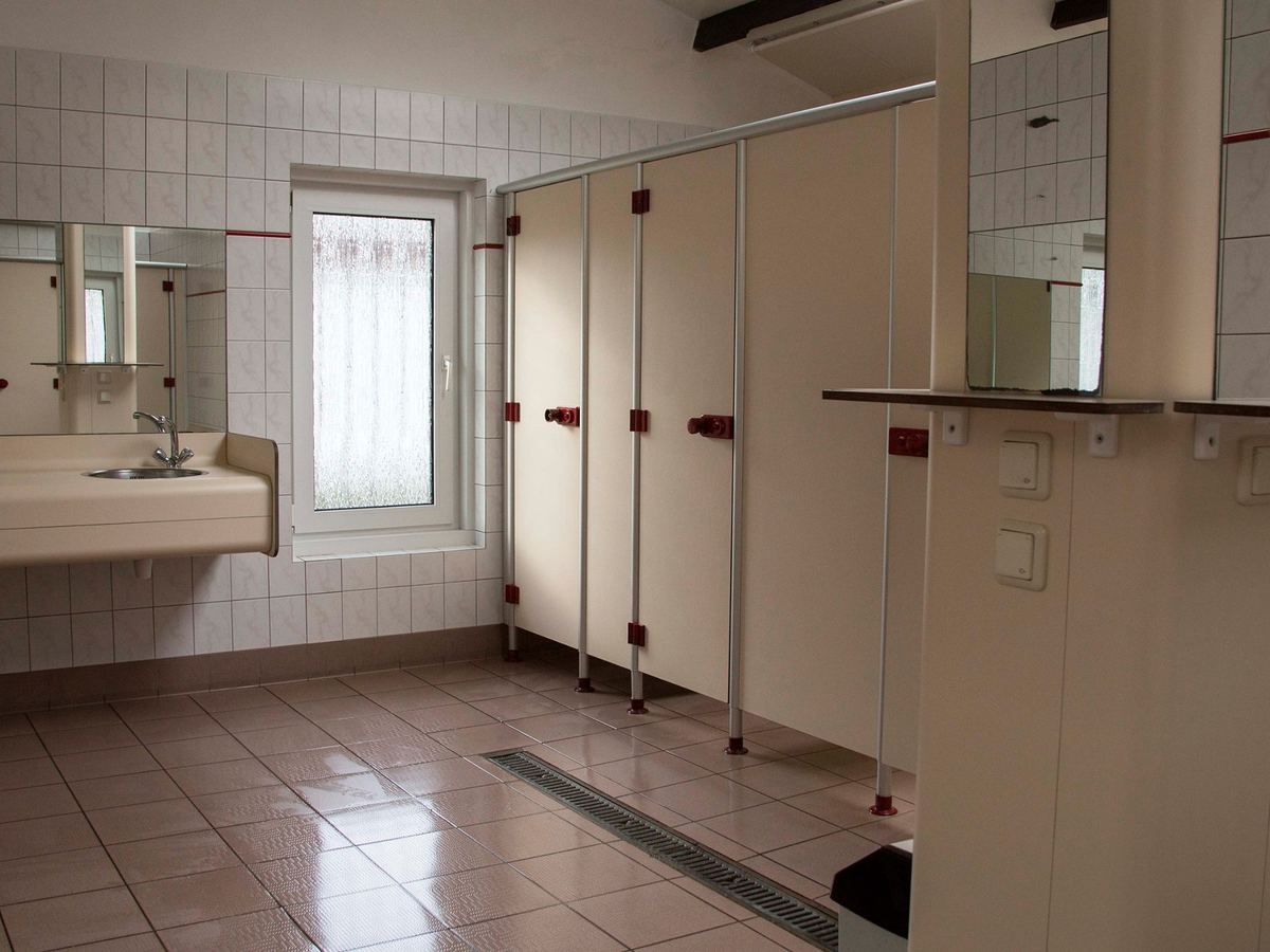 Wascabines met spiegels en wastafels in het sanitairgebouw