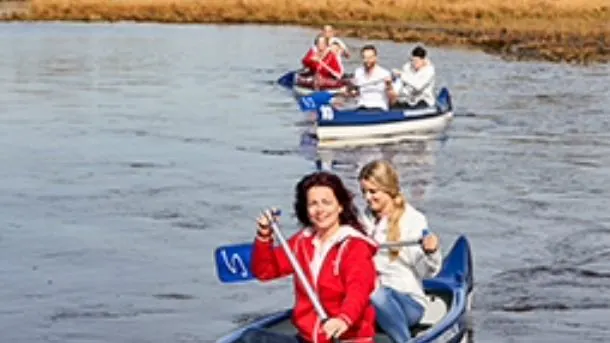 Twee kano's met peddelaars achter elkaar op het water van de Aa