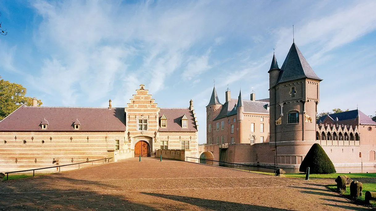 Kasteel Heeswijk met zijn torens achter een breed grasveld