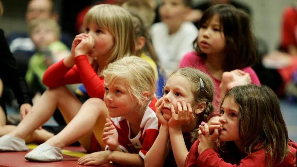 Kinderen kijken vanaf de eerste rij ademloos naar een voorstelling