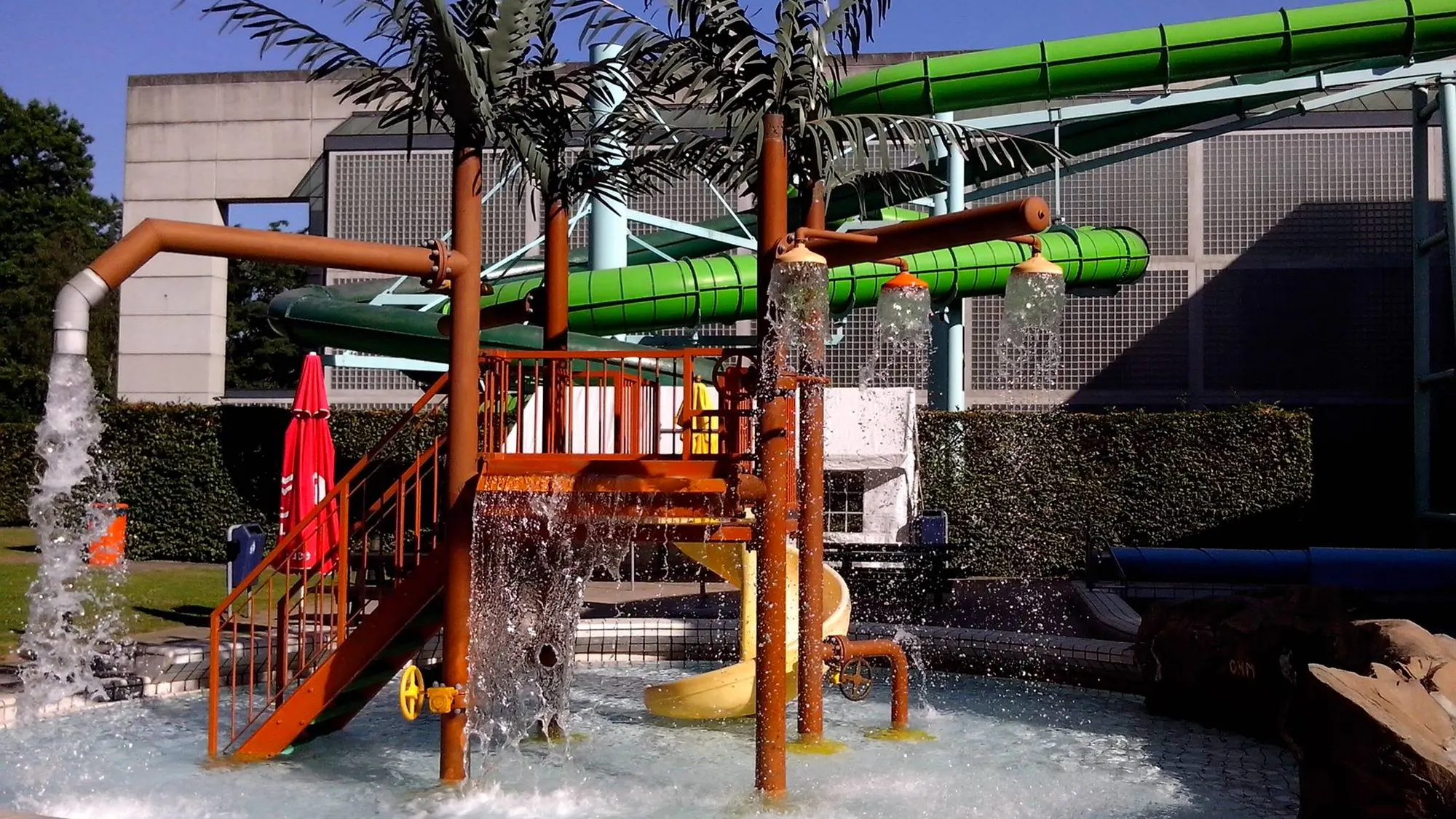 Glijbanen en waterspeeltoestellen boven het kinderbad van het subtropisch zwembad